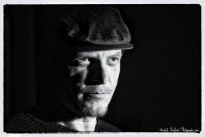 portrait d'homme à casquette au visage buriné clair-obscur en noir et blanc - portrait au flash par le photographe de portrait à Paris Michel Richard