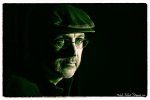 portrait d'homme à casquette au visage buriné en clair obscur et en noir et blanc - couleurs chaudes- portrait au flash par le photographe de portrait à Paris Michel Richard