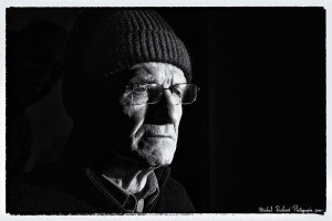 portrait d'homme au bonnet au visage buriné en clair-obscur noir et blanc - portrait au flash par le photographe de portrait à Paris Michel Richard